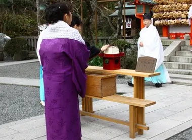 Una mujer que acaba de clavar sus agujas en el pedazo de tofu durante el Hari Kuyo.