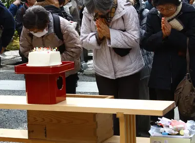 Mujeres orando frente al bloque de tofu donde enterraron sus agujas durante el Hari Kuyo.