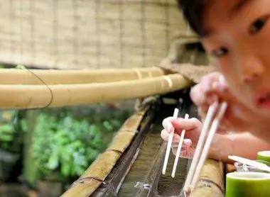 Un enfant essayant de saisir des nagashi-sômen à Kibune.