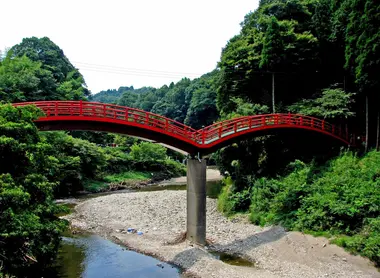 Dans la vallée de Yôrô, un pont rouge traditionnel menant à un temple caché dans la forêt