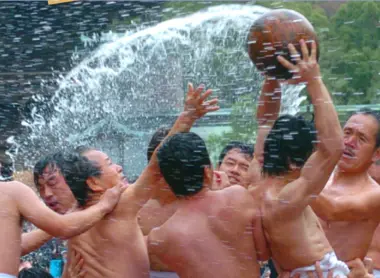 Les participants, presque entièrement nus, s'arrachent l'une des deux boules en bois Les participants, presque entièrement nus, s'arrachent l'une des deux boules en bois