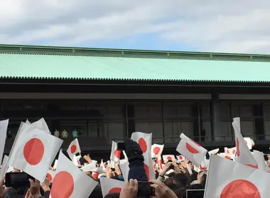 La foule du Palais Impérial agite les drapeaux et tente d'immortaliser l'instant