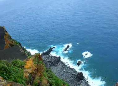 L'eau bleue turquoise contraste avec le sol d'un noir profond. 