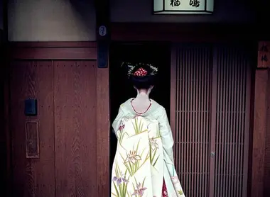 Geisha à l'entrée d'une maison de thé dans le quartier de Gion, à Kyoto