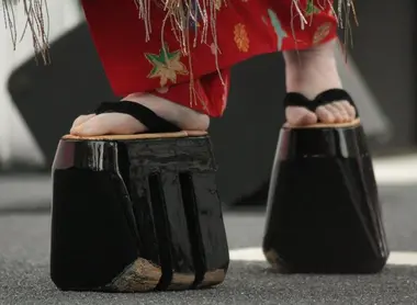 Les oiran effectuent la marche "hachimonji" pour se déplacer, sur leurs sanmaiba geta (soques de bois traditionnelles) 