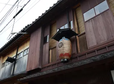 La façade feutrée d'une machiya ornée d'une lanterne