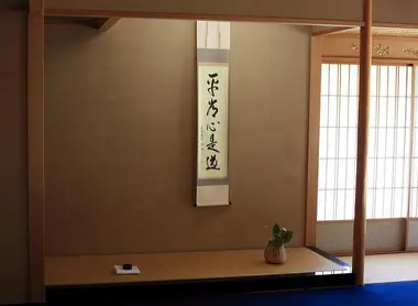 Un rouleau décoratif, kakejiku, est au centre de l'alcôve tokonoma