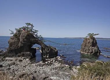 Les rochers, reliés par une cordelette, signe de leur caractère sacré.