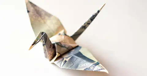 Origami de grue fait avec un billet de 1000 yen