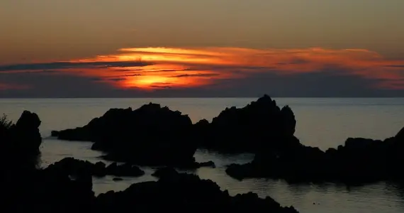 Sunset over rocks in the ocean from Sado Island