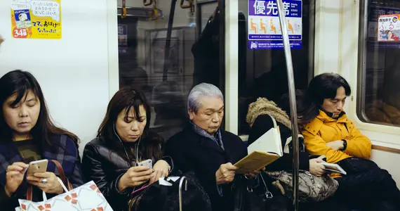 Plusieurs générations assises à côté dans un métro à Tokyo 