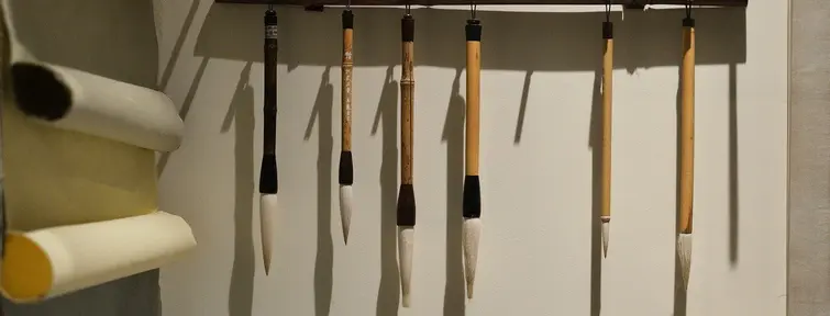 Hanging calligraphy brushes and paper on wall