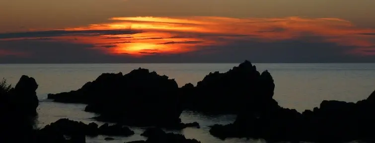 Sunset over rocks in the ocean from Sado Island