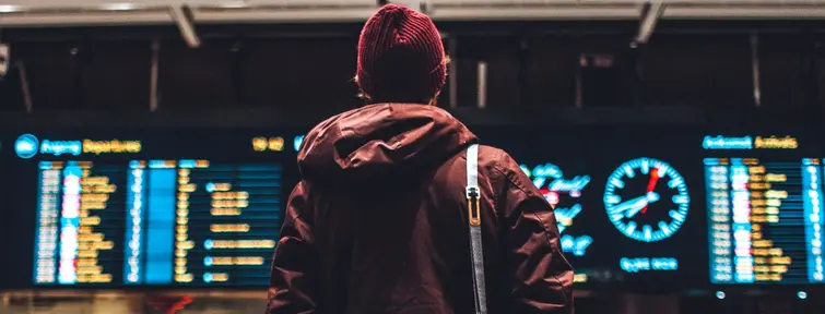 Voyageur devant le panneau d'affichage à l'aéroport